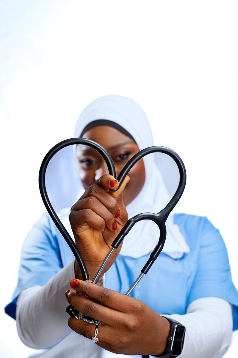 A healthcare professional holding a stethoscope in a heart shape