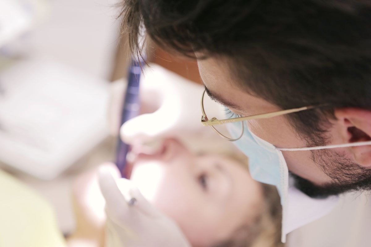 A dental professional carefully examining a patient’s teeth