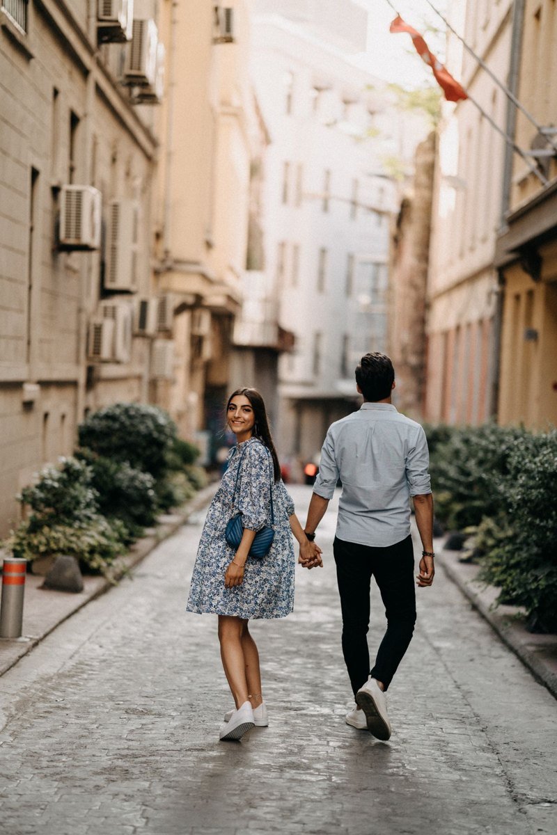 A couple walking together along a leafy neighborhood street