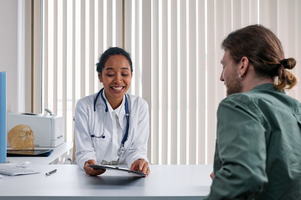A doctor talking with a patient in a bright consultation room